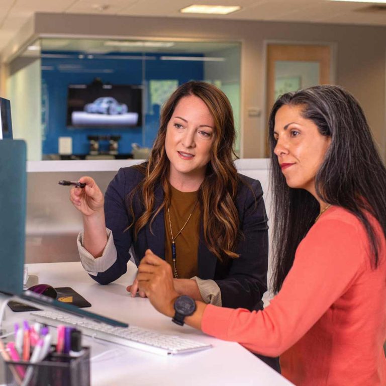 Executive profile development - two women working together at a computer